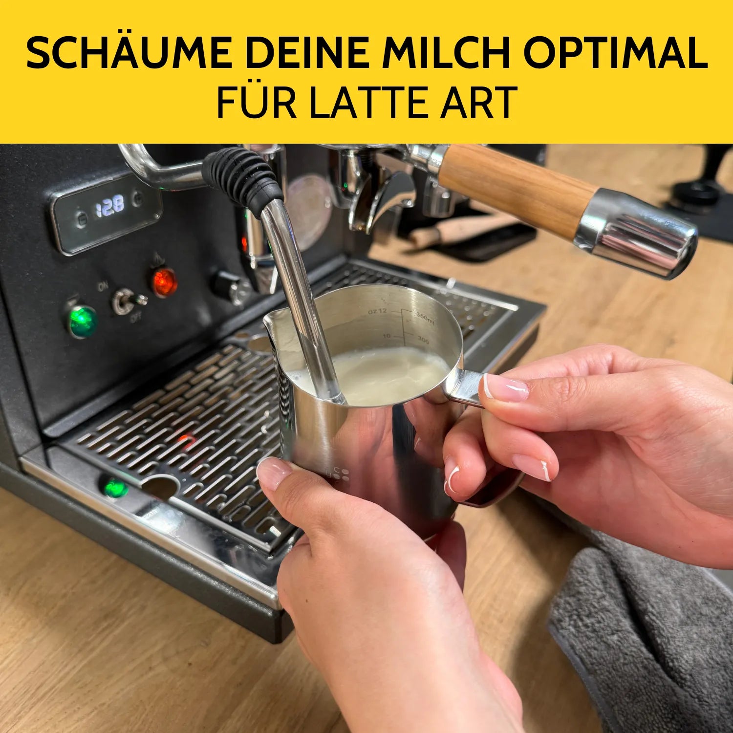 Milch wird im Milchkännchen an der Siebträgermaschine aufgeschäumt.