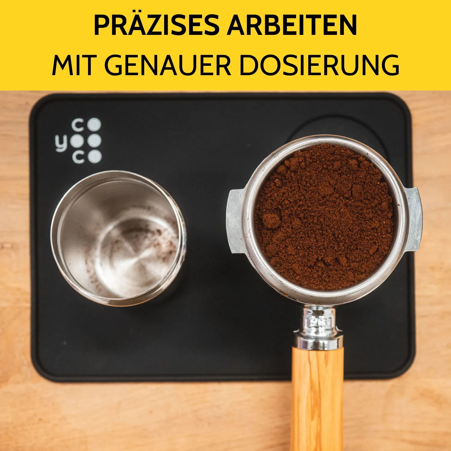 Der Dosierbecher steht neben dem vollen Siebträger auf der Tampermatte.