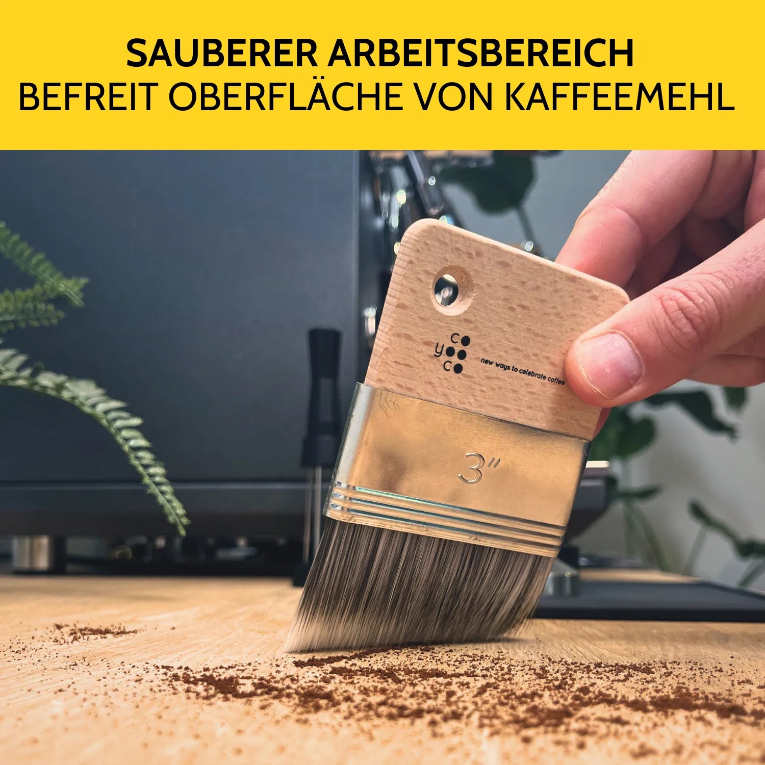 Mit dem Kehrpinsel wird das Kaffeemehl auf der Arbeitsfläche entfernt.