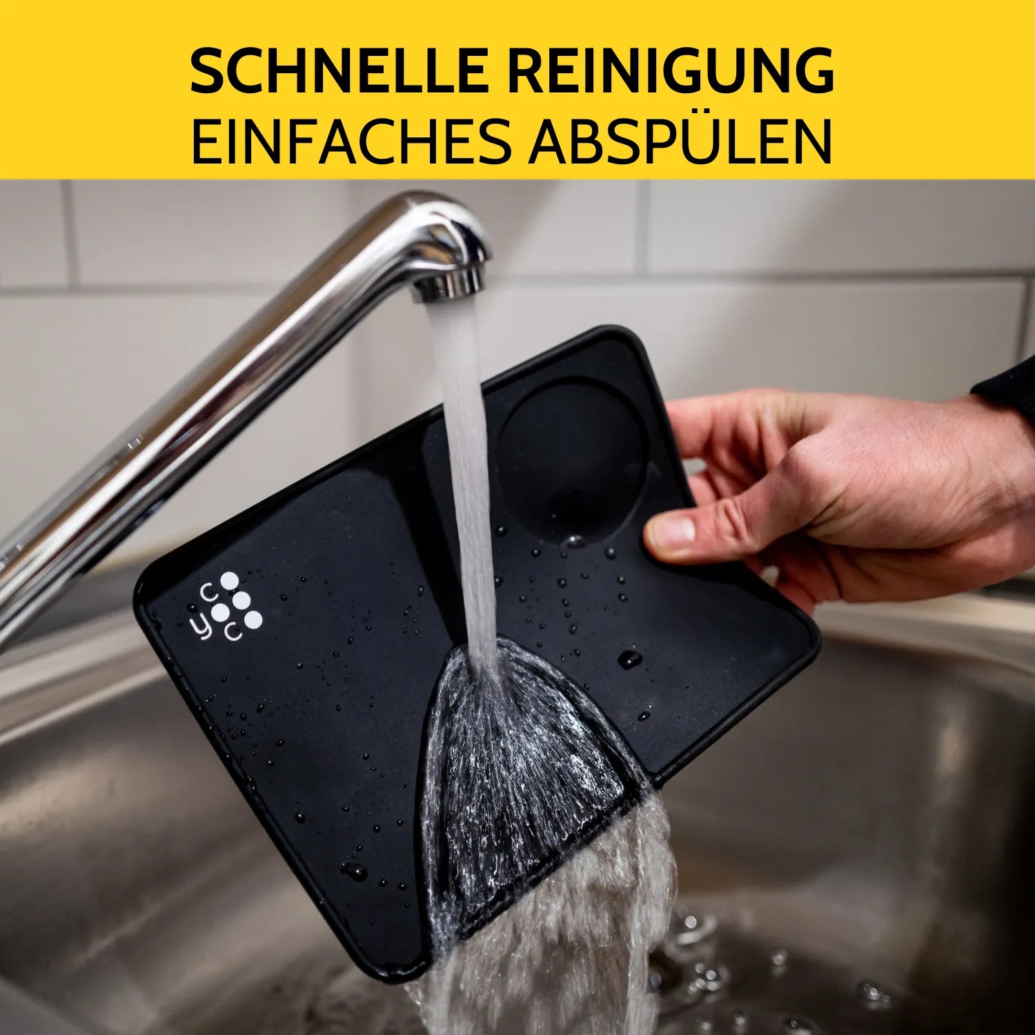 Die Tampermatte wird unter dem Wasserhahn abgespült.