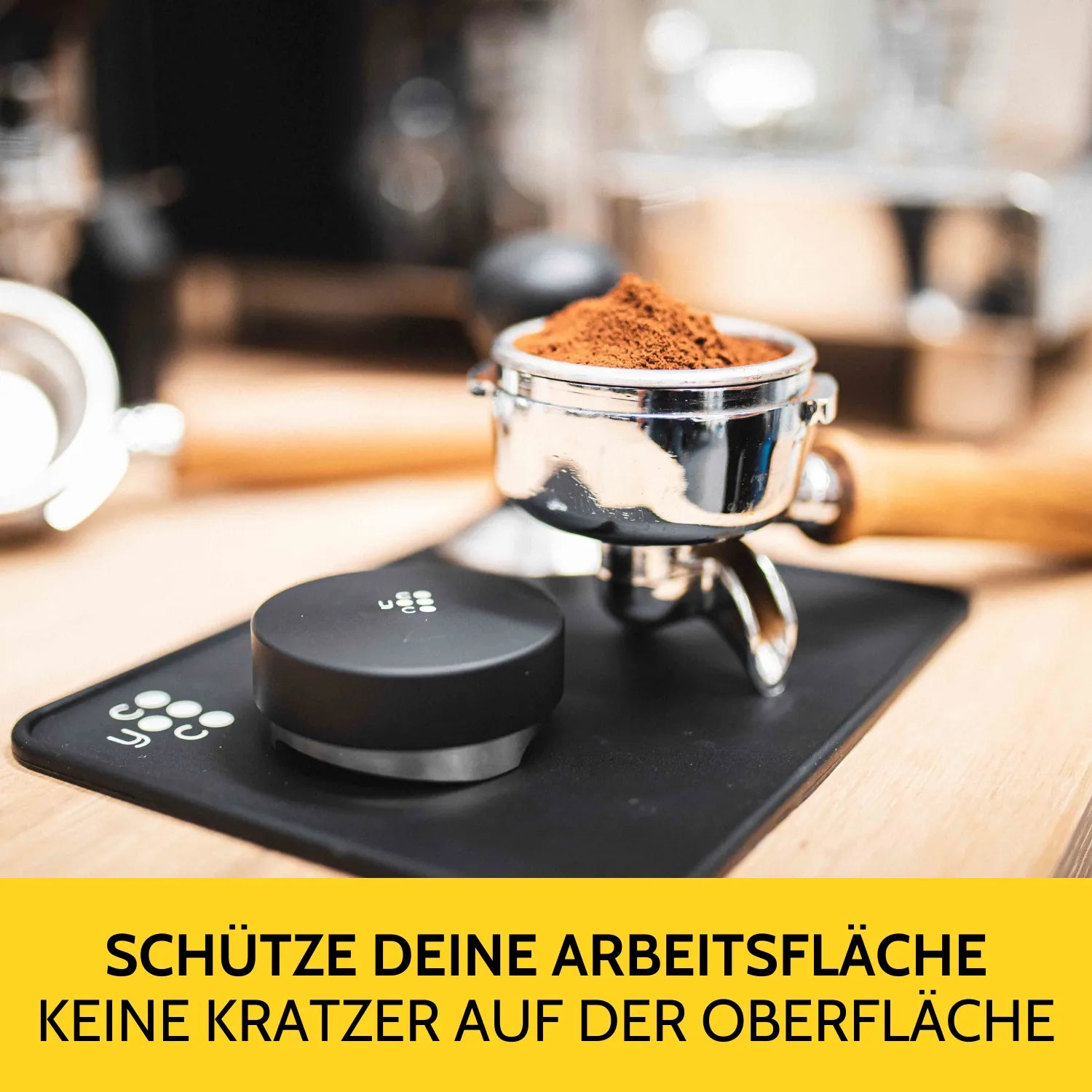 Auf der Tampermatte liegen ein voller Siebträger und ein Leveler.
