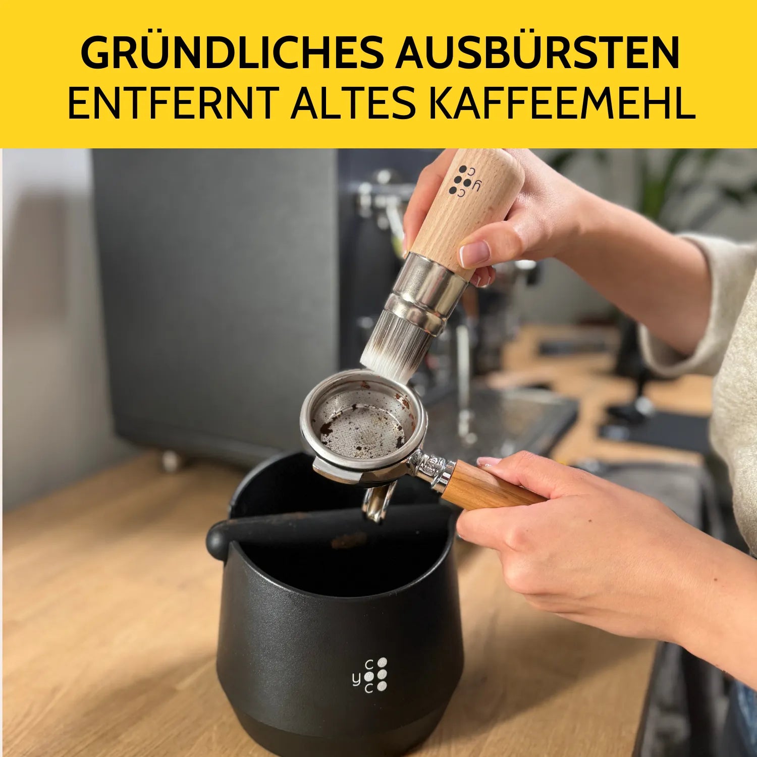 Altes Kaffeemehl wird aus dem Siebträger mit dem großen Barista-Pinsel entfernt. 